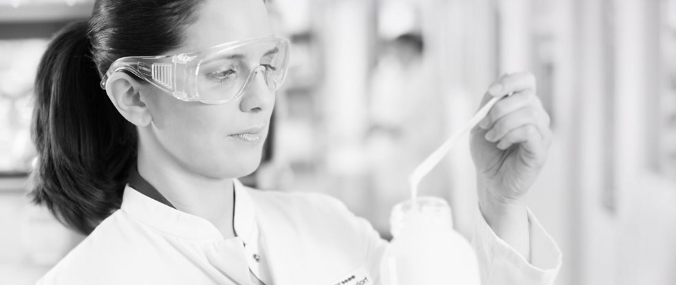 Une chercheuse équipée de lunettes de sécurité testant une formule