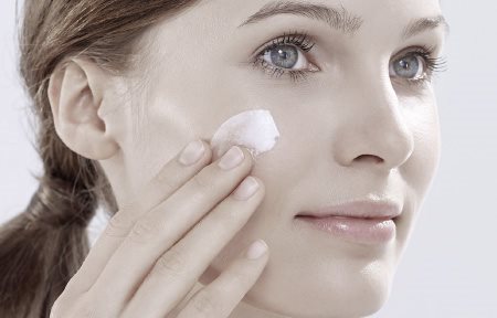 Femme s'appliquant de la crème sur le visage