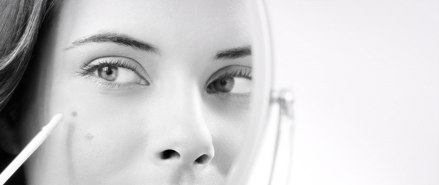 Un modèle Eucerin utilise un stylo correcteur pour masquer ses taches brunes