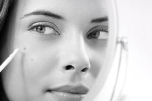 Un modèle Eucerin utilise un stylo correcteur pour masquer ses taches brunes