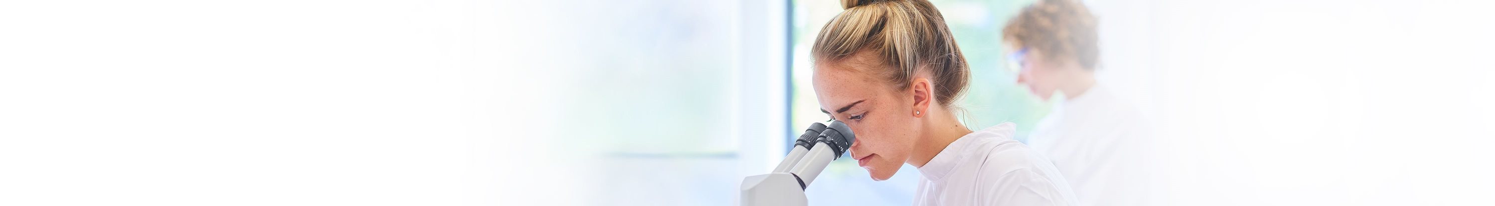 Une femme regarde dans un microscope